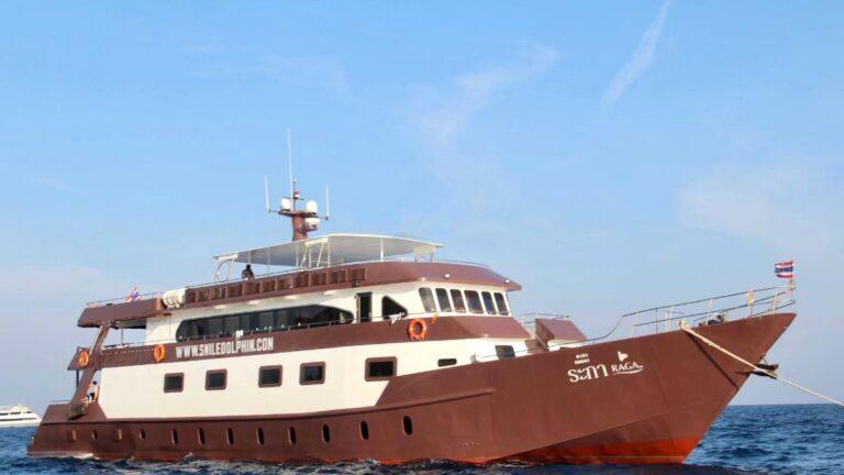 The MV Raga, a brown and white liveaboard dive boat, cruising in the clear blue waters of Thailand.