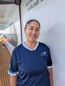 Cake, the housekeeping steward on MV Raga, smiling warmly in her staff uniform.