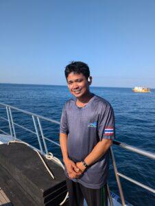 Dinghy driver Lip smiling and keeping a lookout on the deck of the MV Aqua.