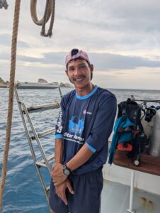 White, the dinghy driver for MV Gentle Giant, laughing happily while standing on the boat ladder.
